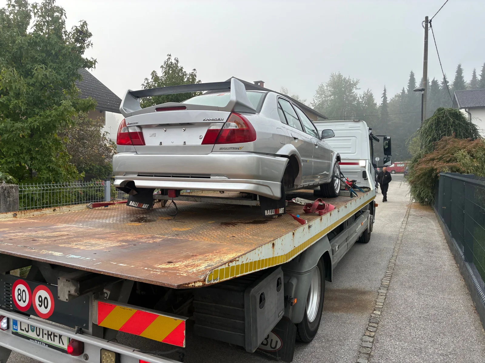 Rear view of the Mitsubishi Evo IV secured on a recovery truck before transport to the workshop